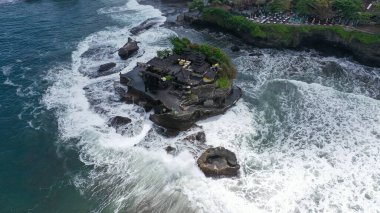 Tanah Lot Tapınağı 'nın nefes kesici manzarası. Tanah Lot, Endonezya 'nın Bali adasında bir kaya oluşumu. Pura Tanah Lot adlı hac tapınağına ev sahipliği yapıyor. Popüler turist ve kültür simgesi.
