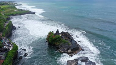 Endonezya, Bali 'de Canggu yakınlarındaki büyüleyici Tanah Lot Bali Hindu tapınağı ve dramatik sahili insansız hava aracı görüntüsü.