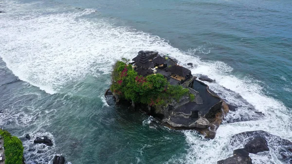 Endonezya, Bali 'de Canggu yakınlarındaki büyüleyici Tanah Lot Bali Hindu tapınağı ve dramatik sahili insansız hava aracı görüntüsü.