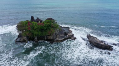Tanah Lot Tapınağı 'nın nefes kesici manzarası. Tanah Lot, Endonezya 'nın Bali adasında bir kaya oluşumu. Pura Tanah Lot adlı hac tapınağına ev sahipliği yapıyor. Popüler turist ve kültür simgesi.