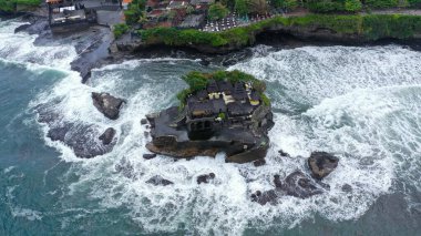 Tanah Lot Tapınağı 'nın tepesinde, denizdeki kayanın üzerinde. Eski Hinduizm ibadet yeri. Güneş ışığı. Hava görüntüsü. Bali, Endonezya.