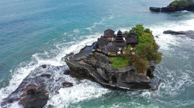 Tanah Lot Tapınağı 'nın nefes kesici manzarası. Tanah Lot, Endonezya 'nın Bali adasında bir kaya oluşumu. Pura Tanah Lot adlı hac tapınağına ev sahipliği yapıyor. Popüler turist ve kültür simgesi.