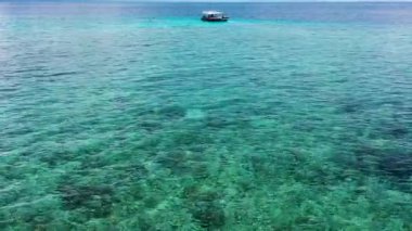 Turistler resifte şnorkelle yüzen tekne yolculuğunun tadını çıkarırlar. Turkuaz deniz yüzeyinde alçak açılı drone uçuşu. Bir grup turist Bali mercan resifinin mükemmel berrak sularında yüzüyorlar. Denizde bir tekne