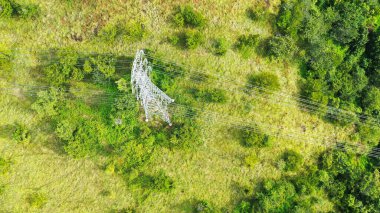 Dağlık arazideki elektrik direkleri ve yüksek voltaj hatları. Yüksek voltaj direkleri. Elektrik iletim güç hatları. 4K, UHD, Sinematik, Hava Görüntüleri