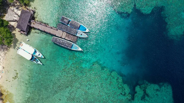 Barcos turísticos en el muelle en el mar azul en la isla de Menjangan. Vista aérea — Foto de Stock