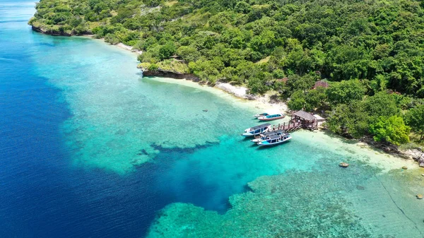 인도네시아의 발리에 있는 망간 섬의 해변 옆에 는 배 한 척 이세워져 있었습니다. 바다에 있는 산호초 위에 배가 세워져 있었습니다. 아름답고 맑은 물. 해변에 나무가 몇 그루있어. 지옥같은 낙원 — 스톡 사진