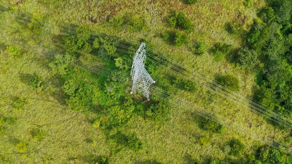 Dağlık arazideki elektrik direkleri ve yüksek voltaj hatları. Yüksek voltaj direkleri. Elektrik iletim güç hatları. 4K, UHD, Sinematik, Hava Görüntüleri