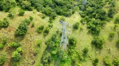Dimmerand 'ı destekle ve yüksek voltajlı hatları dağlık bir arazide yükselt. Yüksek voltaj direkleri. Elektrik iletim güç hatları. 4K, UHD, Sinematik, Hava Görüntüleri