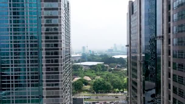 Mergând înainte între zgârie-nori moderni de sticlă din Jakarta. Vedere peisagistică în orașul Jakarta. Zbor aerian în interiorul clădirilor înalte din interiorul districtului de afaceri — Videoclip de stoc