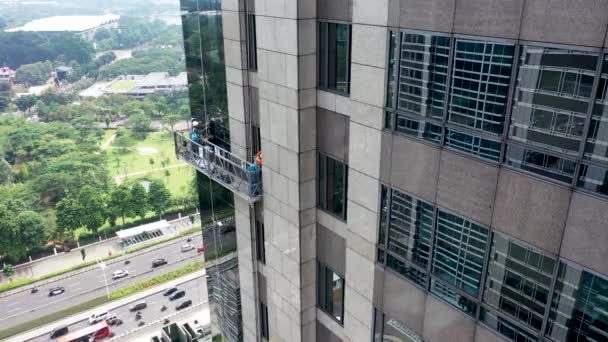 Professionelle Fensterputzer in Gondeln. Zwei Arbeiter benutzen Spezialgeräte, um Fenster des Wolkenkratzers als vorbeugende Wartungs- und Reparaturmaßnahme zu betreten und zu reinigen — Stockvideo
