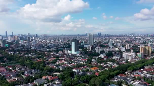 Drone disparo volando sobre edificios de poca altura hacia el horizonte moderno Yakarta, Indonesia urbana — Vídeo de stock