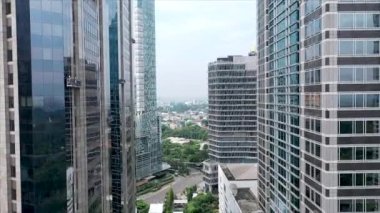 Jakarta City 'deki modern cam binayı kapatın. Modern cam gökdelenler arasında İHA uçuşu.