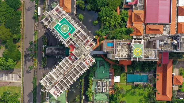 Top down view of helicopter landing pad on the roof of modern skyscraper in Jakarta city.