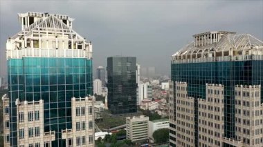 Sisli bir sabahta, bir İHA 'nın gökdelenlerinin arka planıyla Jakarta' nın hava manzarası. Jakarta şehrindeki modern gökdelenin havadan görünüşü. 4k çözünürlükte uçan uçak dönüyor..