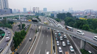 Aerial drone birds eye view photo of latest technology cross shape multi level road highway passing through city center.