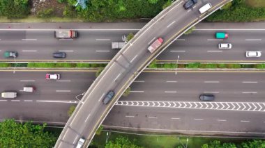 Aerial view following flowing Tomang highway traffic congested urban transport scene. Birds eye above vehicles infrastructure.Jakarta.