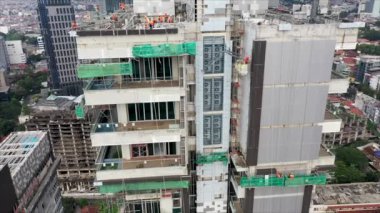 Roof of multistorey building under construction. Modern apartment house builds in the city. Workers build the tower building. Top aerial view.