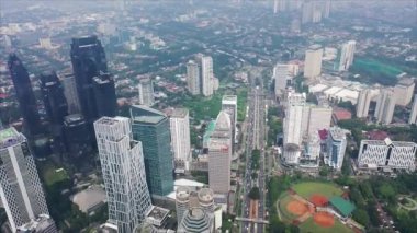 Beautiful aerial view of office buildings in Jakarta downtown from a drone flying upwards. Shot in 4k resolution.