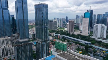 Drone view of residential rooftop with highrise buildings in Jakarta city at morning time.