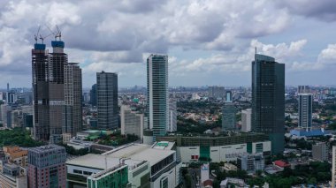 Drone view of residential rooftop with highrise buildings in Jakarta city at morning time.