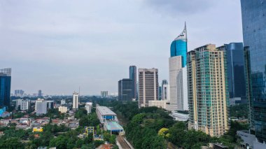 Aerial view of Jakarta city with urban buildings and river at morning time.