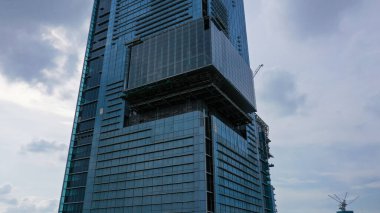 Aerial Close up Construction of high-rise skyscrapers with many floors using cranes. This building is a place of work for trade and business center.