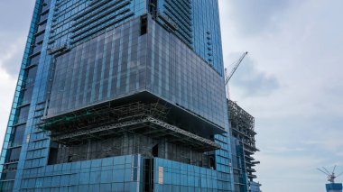 Aerial Close up Construction of high-rise skyscrapers with many floors using cranes. This building is a place of work for trade and business center.
