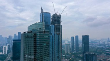 Construction of high-rise skyscrapers with many floors using cranes. This building is a place of work for trade and business center. Twin tower building.