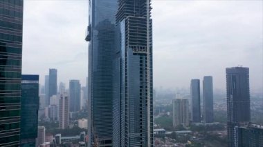 Aerial elevator shot of the modern glass skyscraper exterior with sunshine and reflection on the windows.