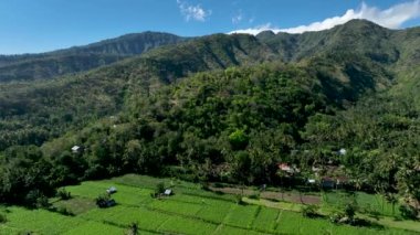 Sabah vakti bir dağ köyünün güzel hava manzarası. Tepelerdeki yeşil ormanlar arasında bulut tepeli dağlara karşı kaybedilen villalar ve evler. Bungalovları olan huzurlu bir kır manzarası..