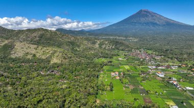Sabah vakti bir dağ köyünün güzel hava manzarası. Tepelerdeki yeşil ormanlar arasında bulut tepeli dağlara karşı kaybedilen villalar ve evler. Bungalovları olan huzurlu bir kır manzarası..