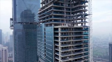 Dışarıdaki cam gökdelenin hava asansörü görüntüsü. Jakarta şehrinde inşaat halindeki yüksek binalar.