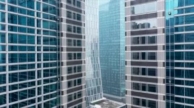 Modern bir şehrin şehir merkezindeki cam gökdelenler arasında uçuyor..