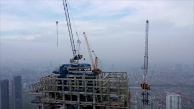 İnşaat alanının üzerinden uçmak, inşaat personeli olarak çalışmak, inşaatçılar, inşaat evleri. Yüksek Kule Vinçleri Emlak Binası ile Yeni Yapılandırma Geliştirme Alanının Üzerinde Hava Uçuşu.