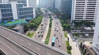 Jakarta 'da gündüz vakti gökdelenlerle Sudirman caddesindeki yoğun trafiğin hava görüntüsü.