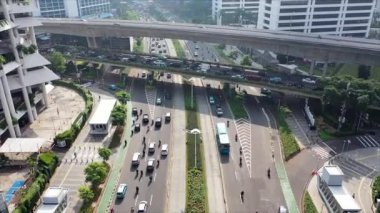 Jakarta 'da gündüz vakti gökdelenlerle Sudirman caddesindeki yoğun trafiğin hava görüntüsü.