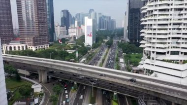 Jakarta 'da gündüz vakti gökdelenlerle Sudirman caddesindeki yoğun trafiğin hava görüntüsü.