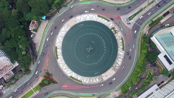 空中鳥の目のオーバーヘッドトップダウン時計の回転Selamat Datang記念碑で忙しい街の交通の眺め夜のラウンド — ストック動画