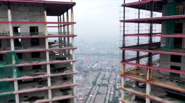 İş gökdelenleri yapım aşamasında, hava manzaralı. Modern, yüksek katlı cam bir bina. İnşaat alanında Yüksek Turnalar.