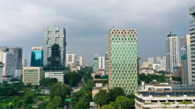 Aerial view of Jakarta city with urban buildings and river at morning time.