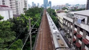 Jakarta City 'de tren. Hava ve alçak açı görüntüleri insansız hava aracı kamerasıyla çekiliyor..