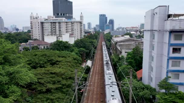 ジャカルタの日中に木を背景に 列車の上を飛んでいくドローン映像 — ストック動画