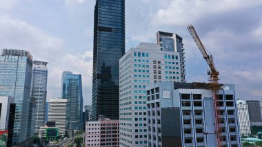Boş trafik manzarası ve diğer gökdelen binalarıyla birlikte inşaat halindeki gökdelen binasının fotoğrafı. Jakarta, Endonezya 'da yakalandı..