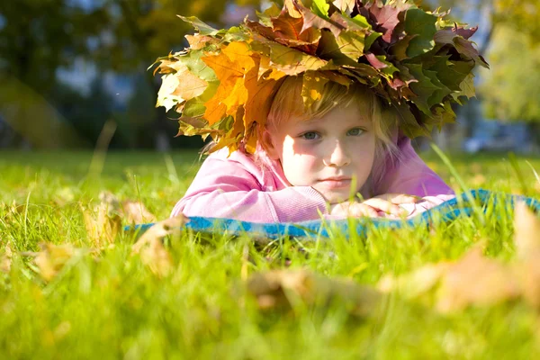 Retrato de una niña de seis años en una corona de hojas de otoño —  Fotos de Stock