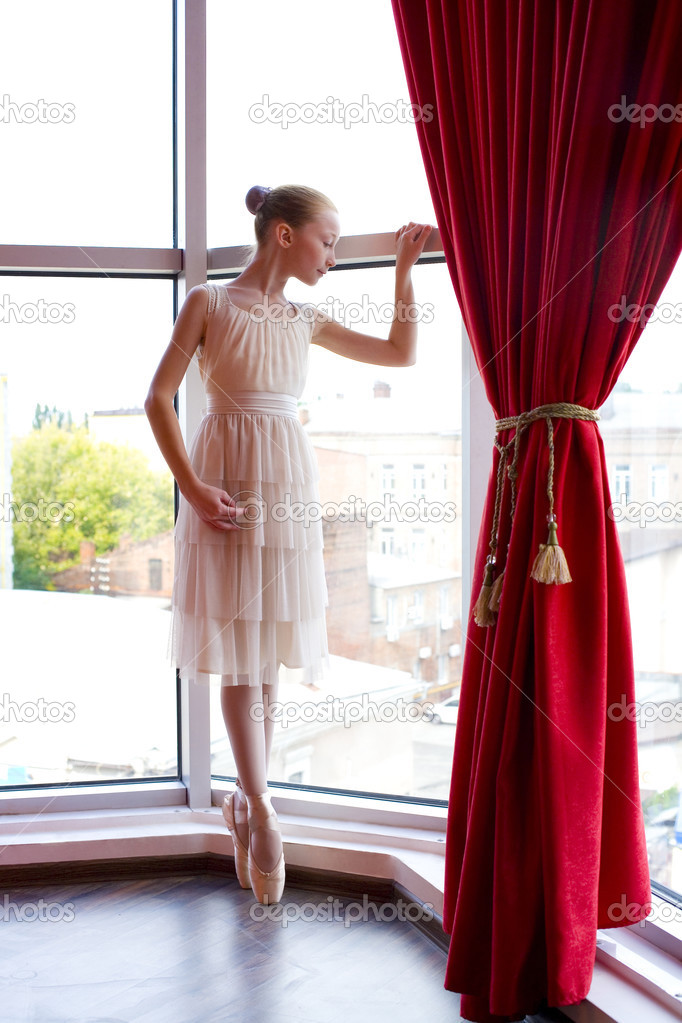 Attractive young ballerina near a window