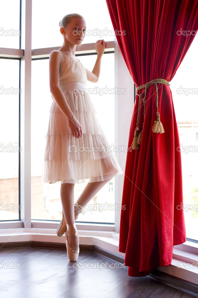 Attractive young ballerina  near a window
