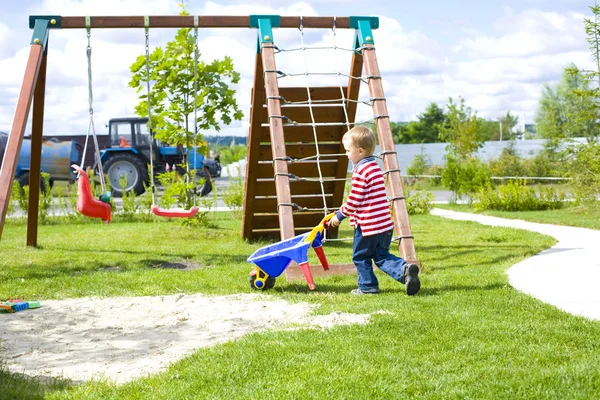 Bambino di quattro anni che gioca in un parco giochi con la sabbia — Foto Stock