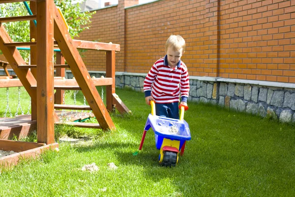 Niño de cuatro años jugando en un parque infantil con arena — Foto de Stock