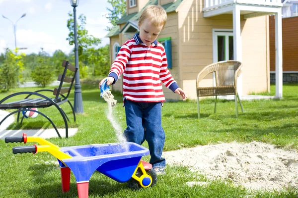 Menino de quatro anos jogando em um playground com areia — Fotografia de Stock