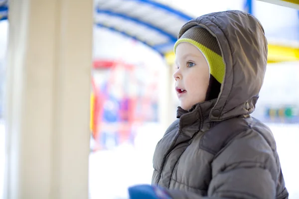 Портрет маленького мальчика на детской площадке зимой — стоковое фото